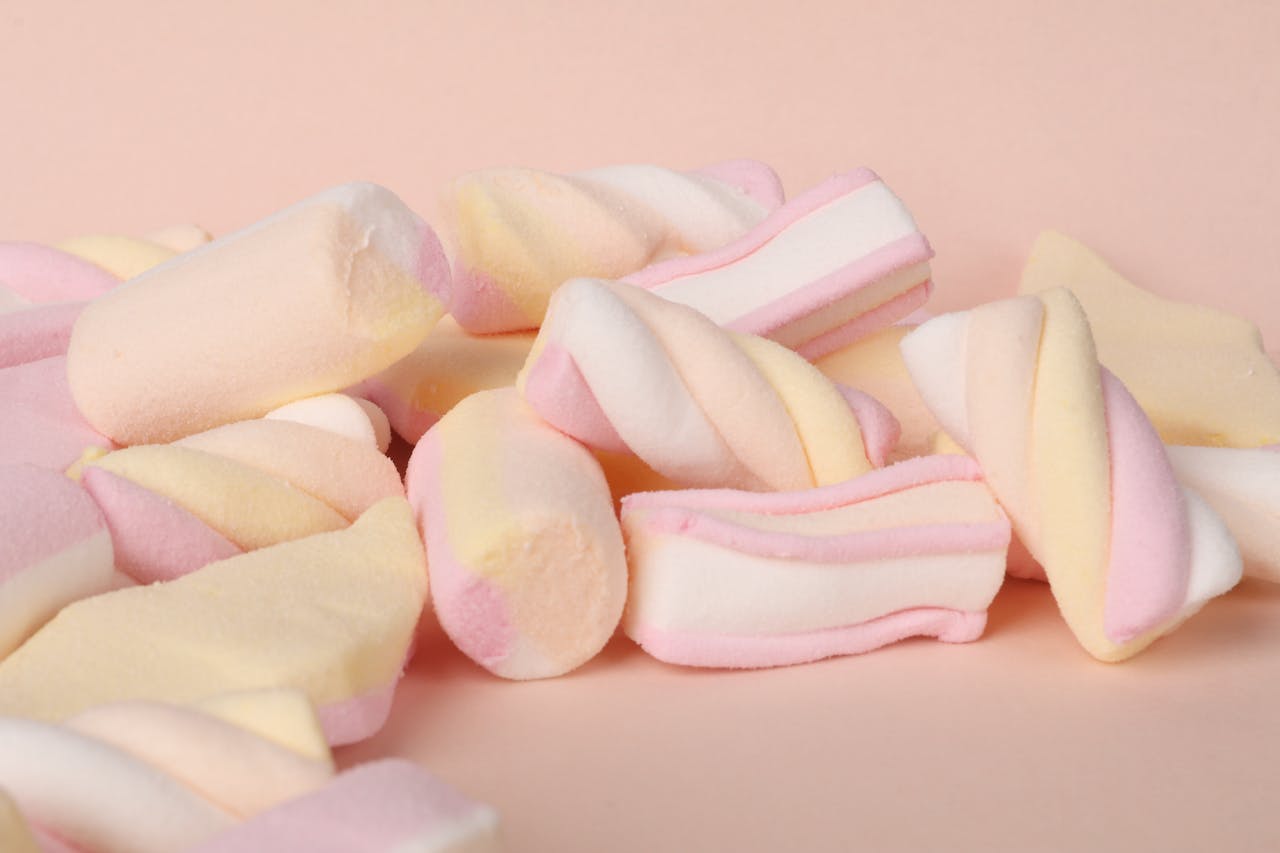 Delicious pastel marshmallows piled up in a soft, light setting, perfect for candy lovers.