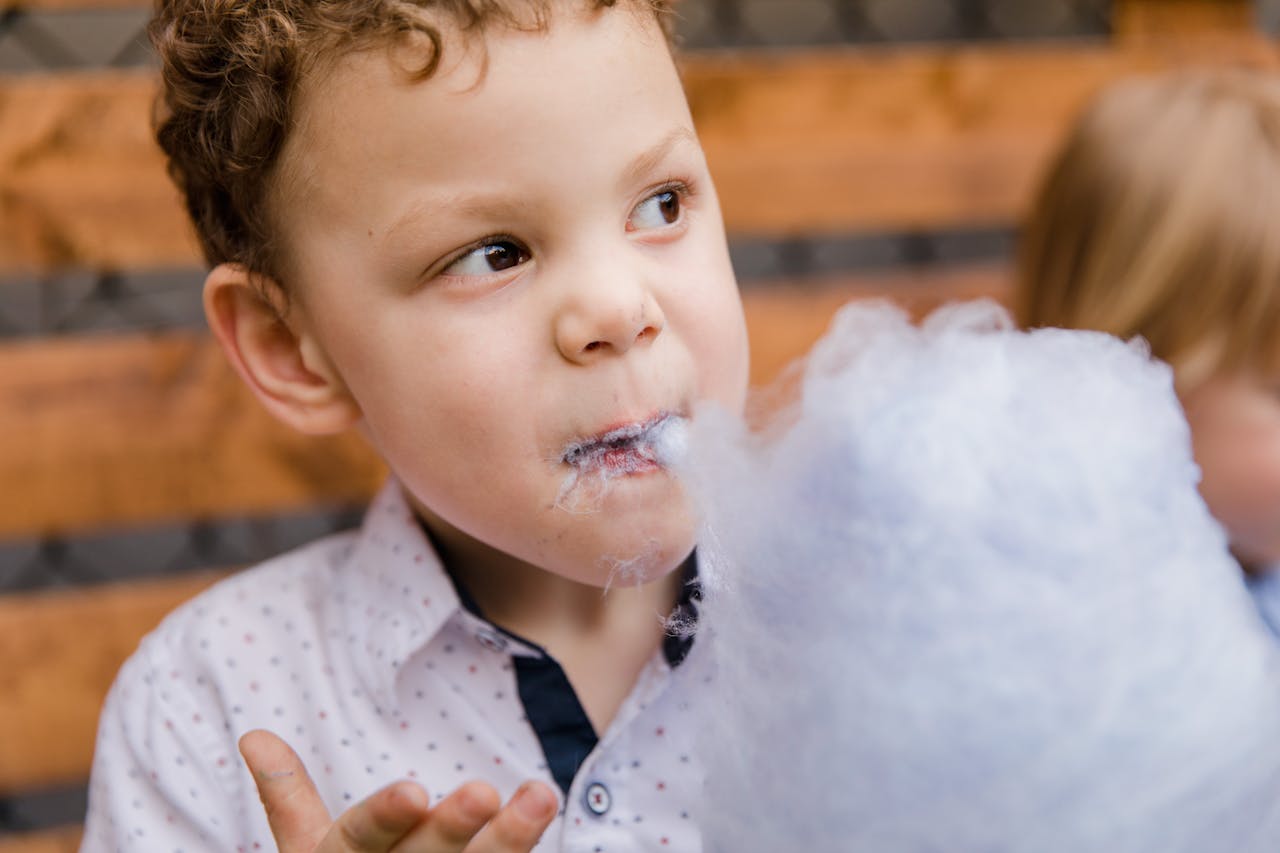 A child delighting in cotton candy, capturing a playful and sweet moment.